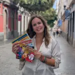 Elena Fuenar sosteniendo sus libros y enseñándolos