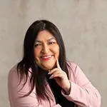 Marcia Paola Rodríguez Sonriendo a la cámara en primer plano con una americana rosa
