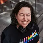 Marta Torre sonriendo a la cámara con una camiseta que mone human