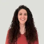 Silvia Rubi en primer plano sonriendo con jersey rojo y pelo largo suelto